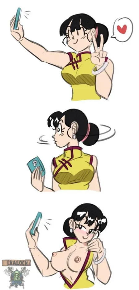 Chi-Chi se toma una selfie erótica bajándose el vestido amarillo para exponer sus pechos grandes y pezones erectos.